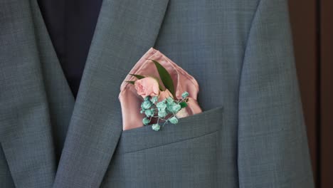 close up of light blue groom's suit with pink and blue floral pocket square boutonniere