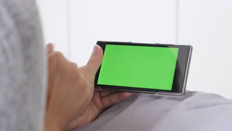 mujer rubia relajándose en la cama en la pantalla verde de la tableta
