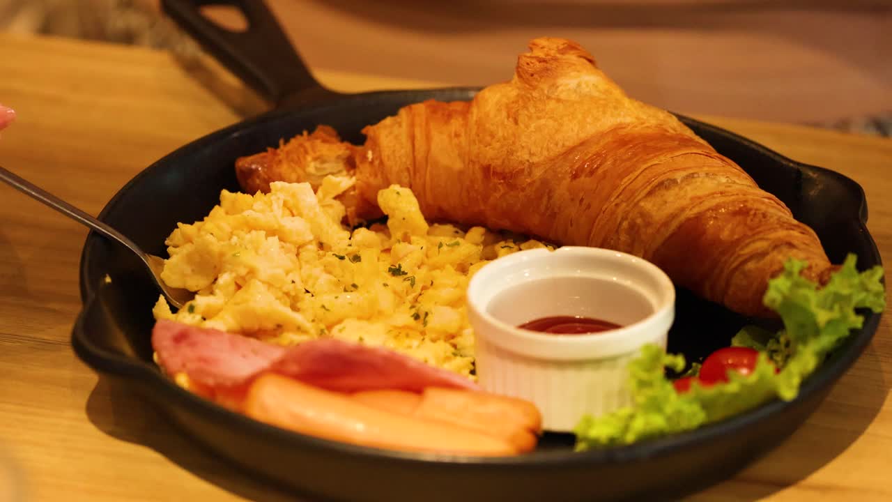 Gustare una ricca colazione con croissant e prosciutto
