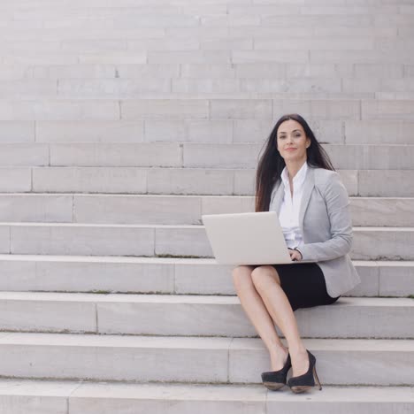 Business-woman-with-laptop-on-stairs