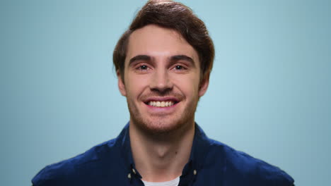 Handsome-man-smiling-on-blue-background.-Smiling-guy-standing-in-studio