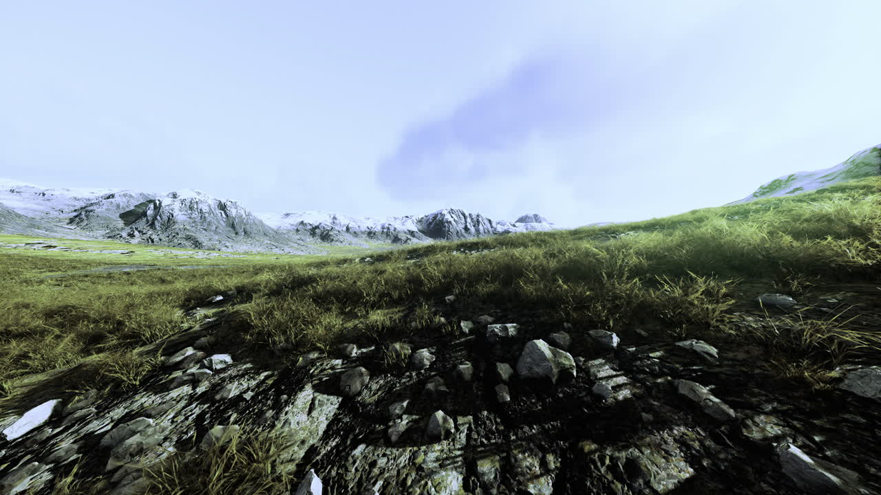 Rolling hills and majestic mountains under a bright blue sky