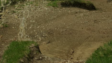 paseos en bicicleta de montaña a través de un charco profundo en cámara lenta