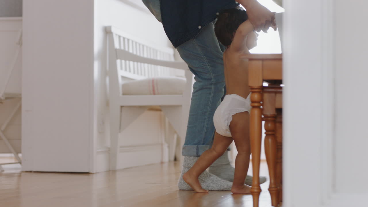 bebé aprendiendo a caminar niño pequeño dando sus primeros pasos con el padre ayudando al bebé enseñando al niño en casa