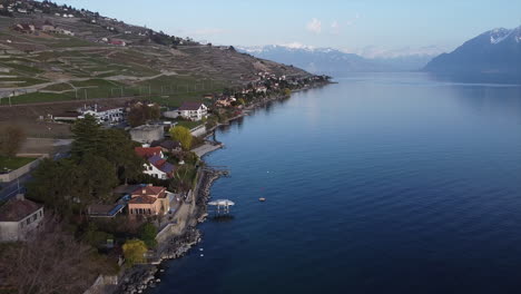 Aerial-fly-along-the-Lake-Geneva-waterfront-near-Lutry,-Switzerland-on-a-sunny-day