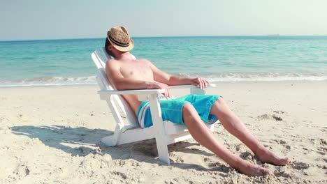 Hombre-Descansando-En-Una-Tumbona-En-La-Playa.