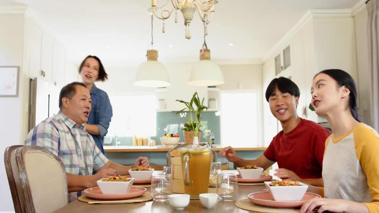 Eating together, family enjoying meal and conversation in kitchen dining area
