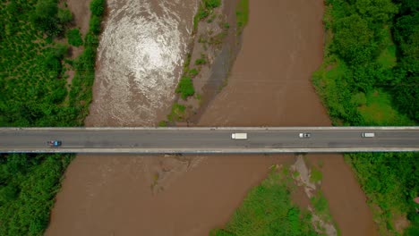 aerial over a busy highway and muddy waters of river tarcoles, costa rica