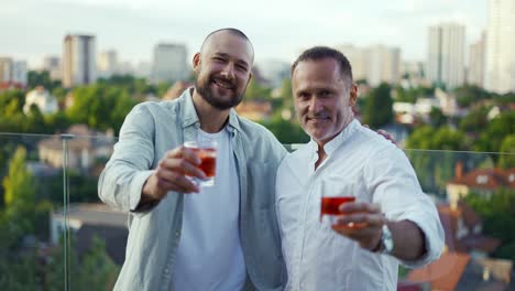 Two-happy-businessmen-are-holding-cocktails-and-posing.-Meeting-of-friends---businessmen.-Celebration-of-and-important-event