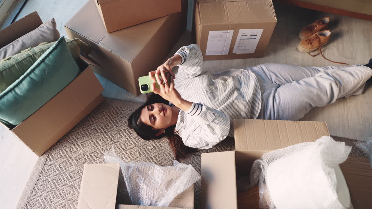 Woman taking photo of boxes after moving into new home