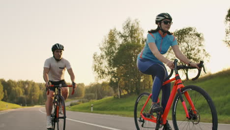 Ciclista-Montando-En-Bicicleta-De-Carretera-Vista-Trasera.-Hombres-Ciclistas-Pedaleando-En-Bicicleta-De-Carretera-En-El-Parque-De-La-Ciudad.-Toma-De-Seguimiento-De-Ciclistas-En-Bicicleta-De-Carretera-Al-Atardecer.-Atleta-Ciclista-Entrenamiento-Intensivo-En-Bicicleta.