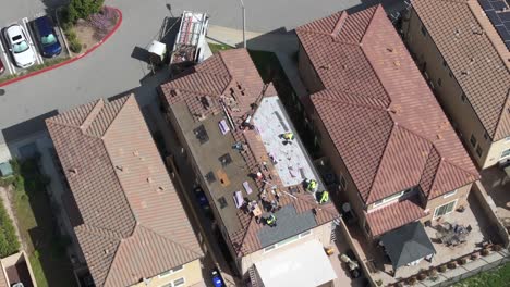 construction crew preparing house roof for solar panel installation in residential neighborhood