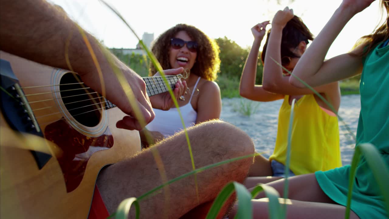 Uomo americano caucasico che suona la chitarra in vacanza al mare.
