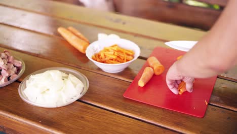 Close-up-The-guy-is-cooking-pilaf-Is-in-the-summer-house-cuts-carrots