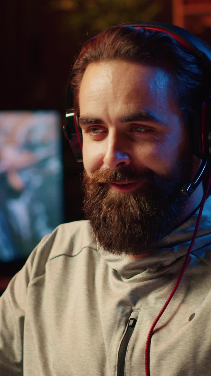 Video verticale. Gamer sorridente che parla con i compagni di squadra mentre gioca a un torneo competitivo di eSport