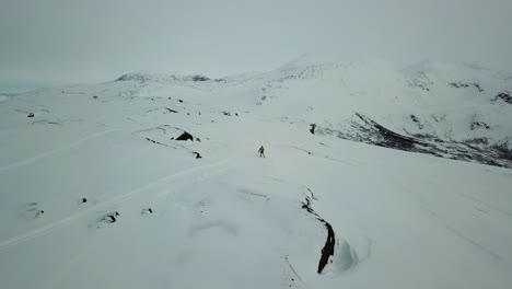 Skier-skiing-down-from-mountain-side