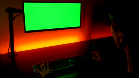 Pantalla-Verde:-Toma-Sobre-El-Hombro-De-Un-Hombre-Caucásico-Escribiendo-En-El-Teclado-Frente-Al-Monitor