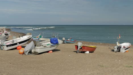 Barcos-De-Pescadores-En-La-Playa-Con-Agua-En-El-Fondo-De-Una-Amplia-Toma-Panorámica