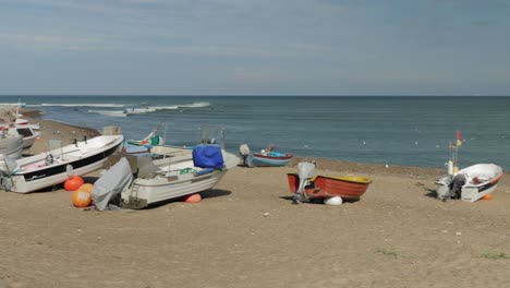 fisherman boats at the beach with water in background wide panning shot