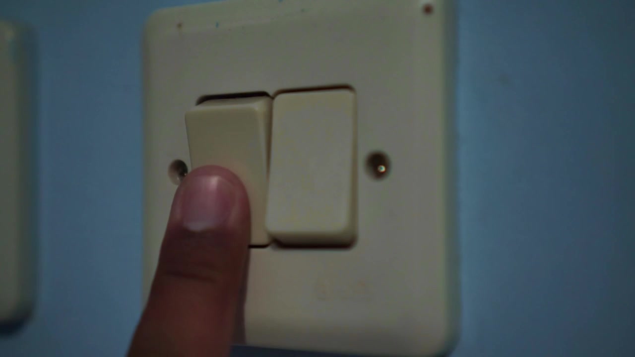 Finger pressing light switch on wall, turning on electricity, home interior detail, energy concept, power control.