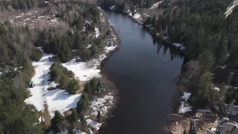 drone fly above river with snow forest pine tree in saint-côme is a municipality in the lanaudière region of quebec canada