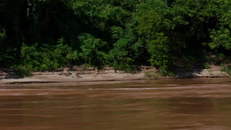 empty long boat transportation passing by on the river, tropic climate