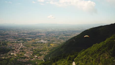 Paraglider-flying-close-to-Monte-Grappa-with-aerial-view-over-Po-valley