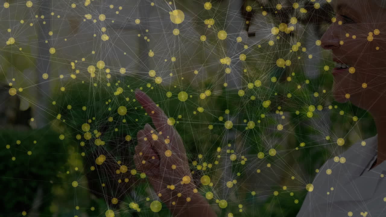 Senior woman touching virtual nodes in garden, presenting digital network with glowing overlay