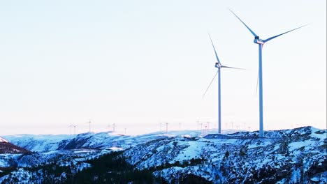 montañas de invierno y turbinas eólicas cerca de bessaker, noruega