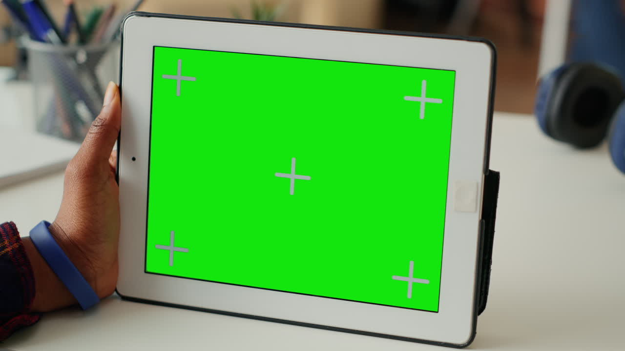 Modern person looking at horizontal greenscreen display on tablet