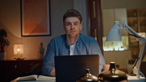 happy freelancer looking camera late workplace portrait. student man relaxing