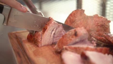 closeup of a chef cutting a pork beef, slow motion