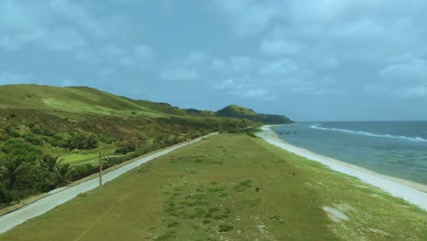 una foto de un dron de campos verdes cerca del mar en sabtang, batanes