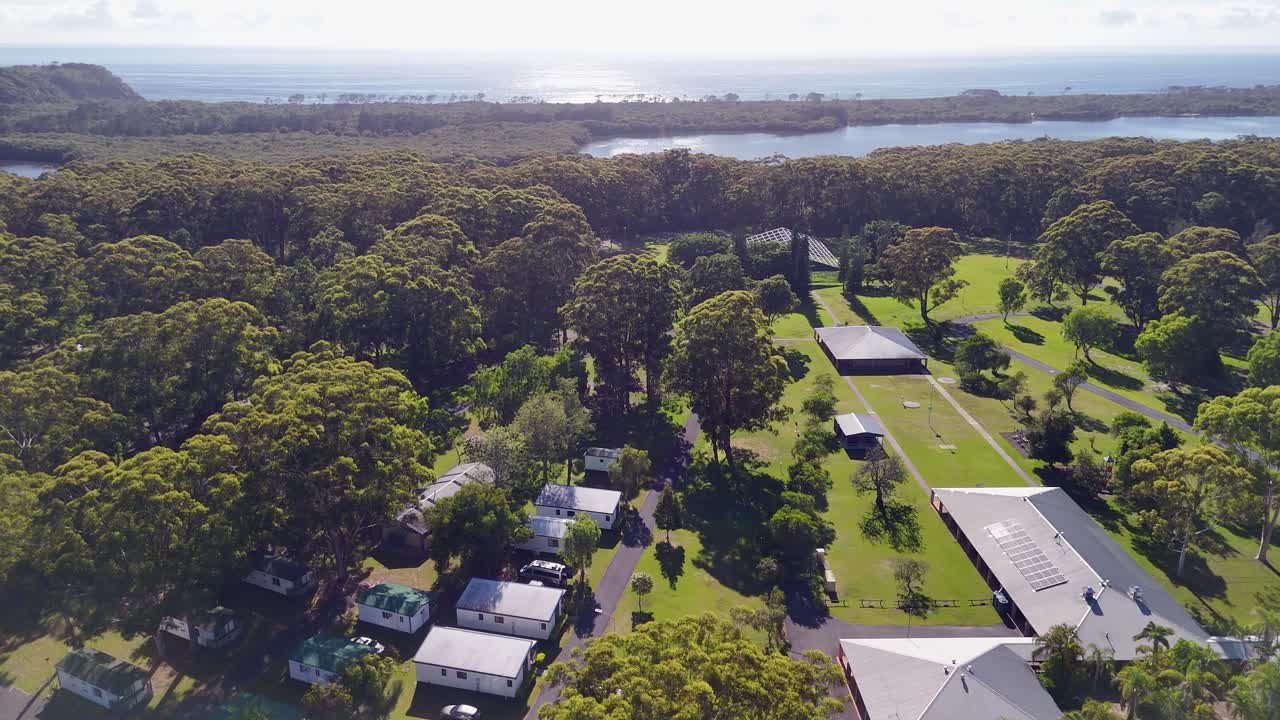 Flyover manicured grounds of Yarra Holiday Park on NSW coast, Australia