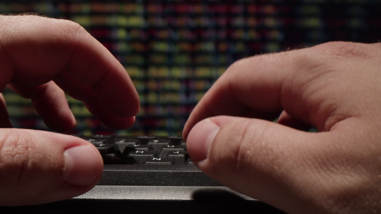 manos escribiendo en un teclado frente a una pantalla del mercado de valores