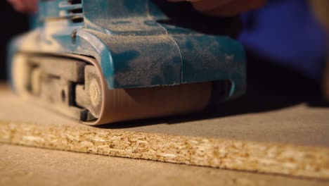 belt sander working on wood panel