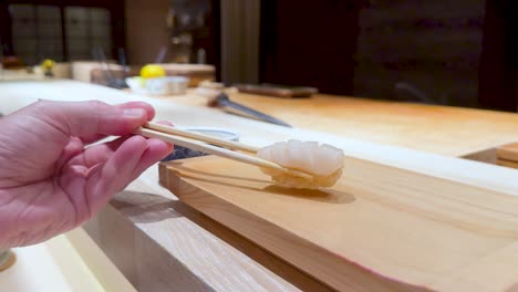 chopsticks picking sushi at a japanese restaurant