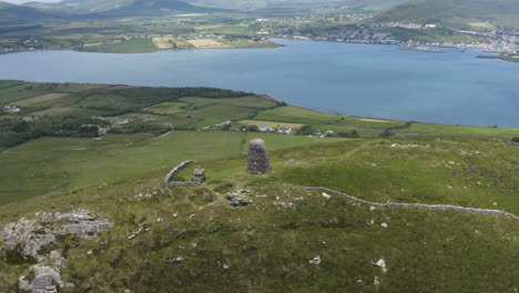 rocky castle ruins on dingle peninsula grassy hill in ireland, aerial