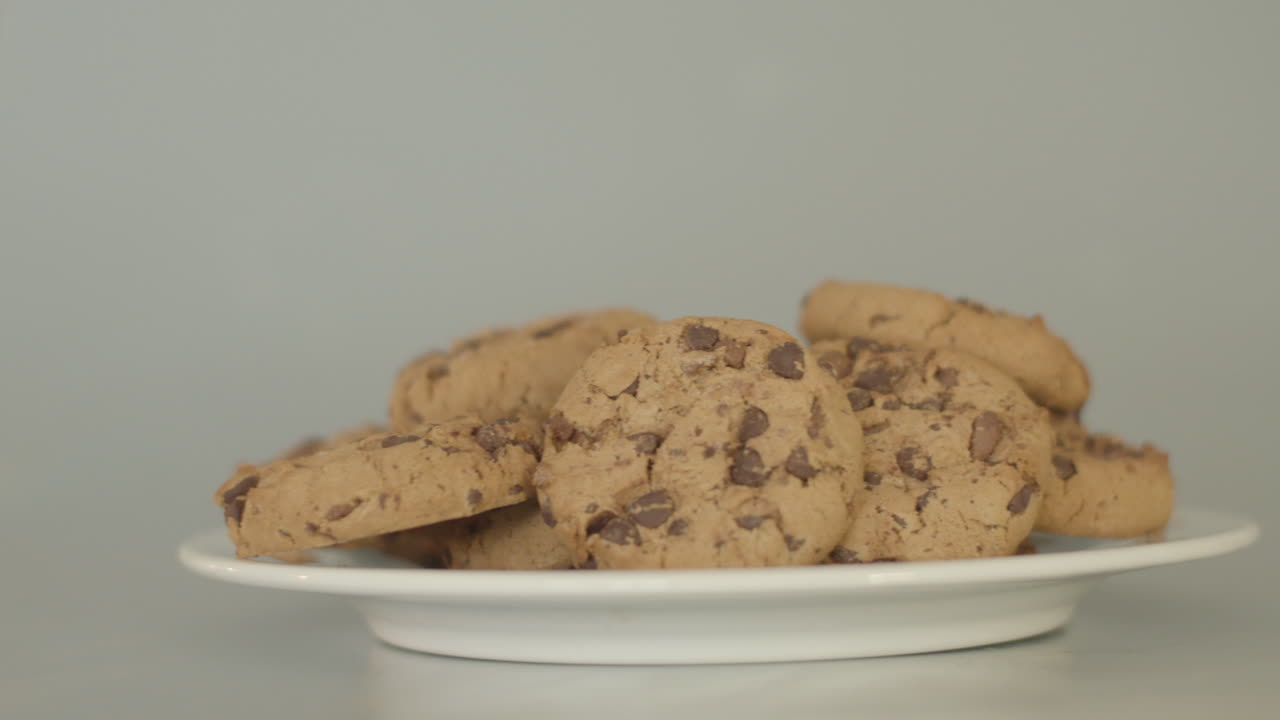 Pile of chocolate chip cookies on a white plate - dolly left