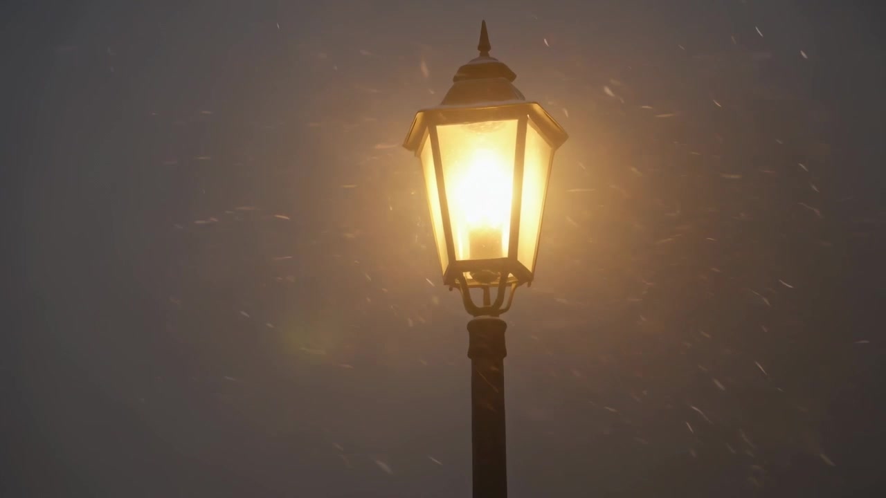 Lanterna stradale ornata e luminosa su un palo di metallo di notte, con la lampadina accesa mentre iniziano a cadere i fiocchi.