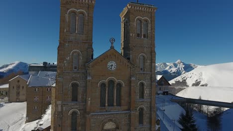 flying over the church and sanctuary la salette during winter, snowy landscape.