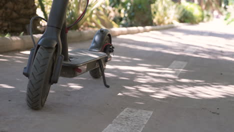 close-up van een onherkenbare vrouw die op een elektrische scooter rijdt in de stad 2