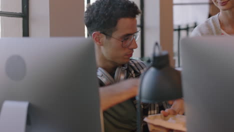 joven hombre caucásico usando computadora navegando en línea trabajando en un proyecto de la compañía mujer de negocios colega compartiendo café mostrando apoyo en una oficina moderna