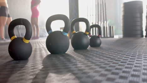 kettlebells lined up on gym floor, ready for female fitness workout session, copy space