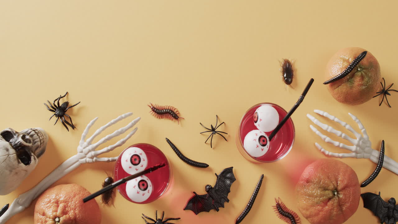 노란색 배경에 복사 공간과 함께 할로윈 음료와 장식의 비디오