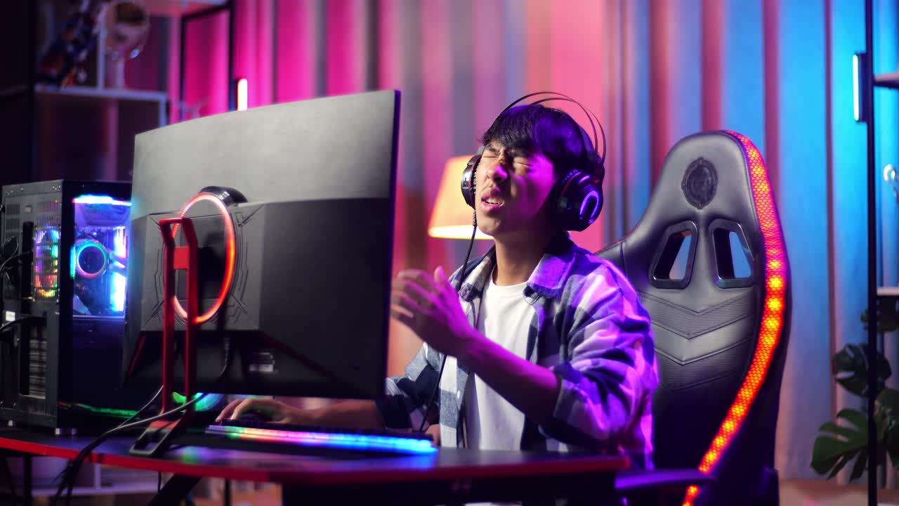 Giovane gamer asiatico perde mentre gioca a un videogioco al computer.