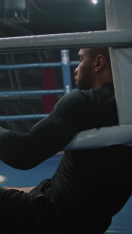 man resting in boxing ring