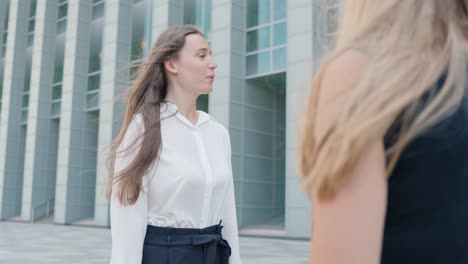 mujer de negocios feliz hablando cerca de un edificio de oficinas, vista de mano