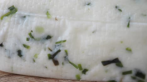 primer plano de queso blanco con hierbas verdes