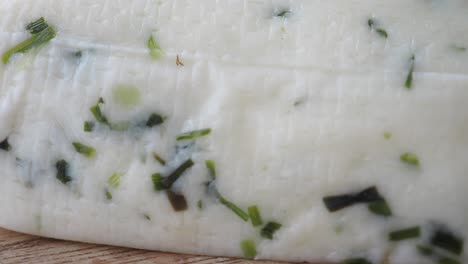 close-up of white cheese with green herbs